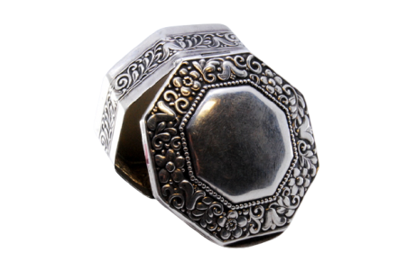 Caixa de comprimidos em prata com motivos florais em forma hexagonal e interior dourado com tampa basculante.
